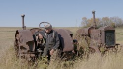 Assis près d’un des anciens tracteurs familiaux, Herb Pidt se remémore les joies et défis de la vie sur la ferme.